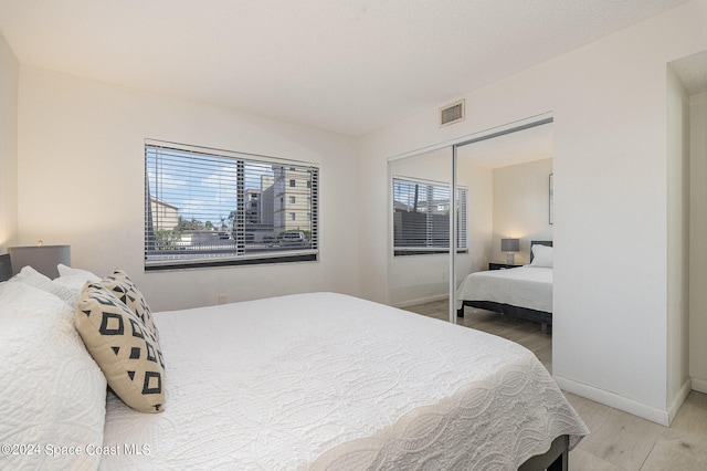 bedroom with a closet and hardwood / wood-style floors