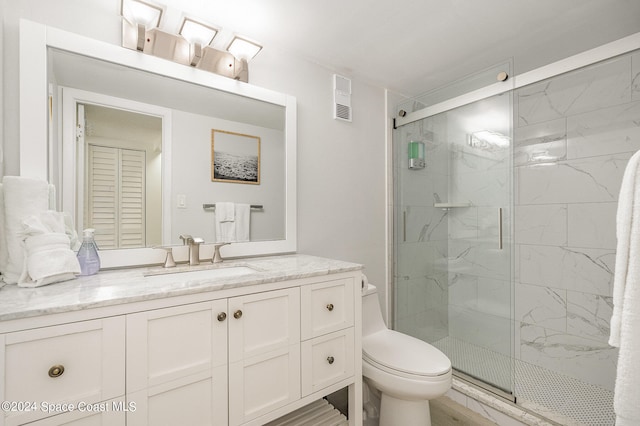 bathroom with toilet, hardwood / wood-style floors, walk in shower, and vanity