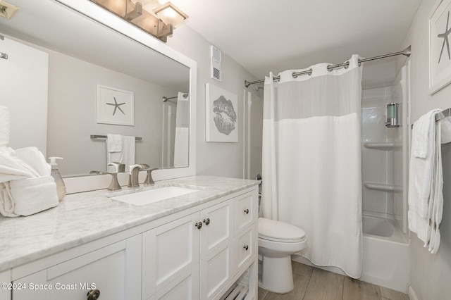 full bathroom with vanity, shower / tub combo, hardwood / wood-style flooring, and toilet