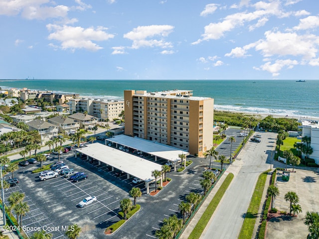 drone / aerial view with a water view and a beach view