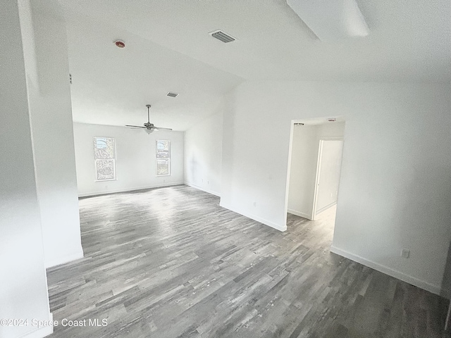 spare room with a textured ceiling, ceiling fan, wood-type flooring, and vaulted ceiling