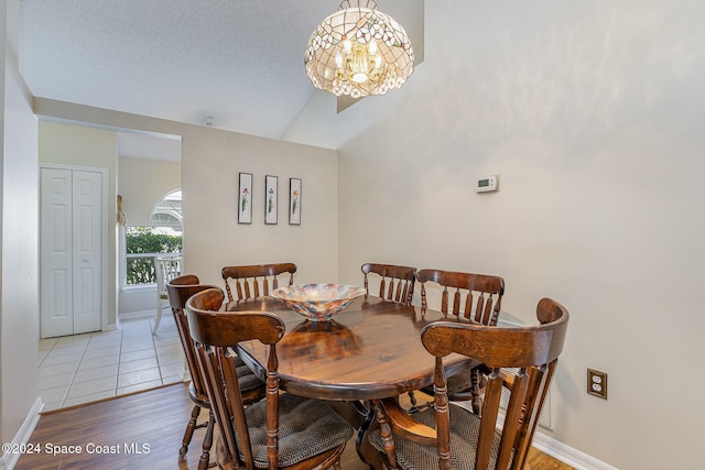 dining space with vaulted ceiling and hardwood / wood-style floors