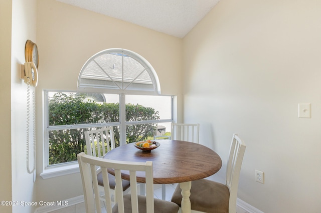 dining space with lofted ceiling and a textured ceiling