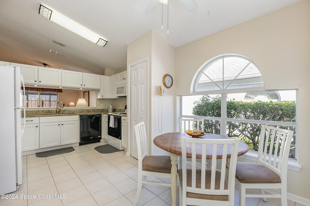 kitchen featuring lofted ceiling, light tile patterned floors, white cabinetry, a textured ceiling, and white appliances