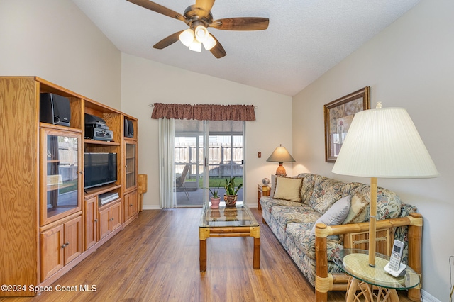 living room with ceiling fan, a textured ceiling, vaulted ceiling, and dark hardwood / wood-style floors