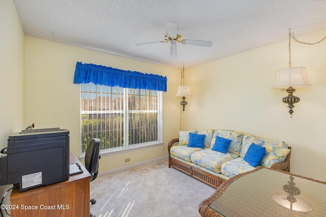 office featuring ceiling fan, a textured ceiling, and light colored carpet