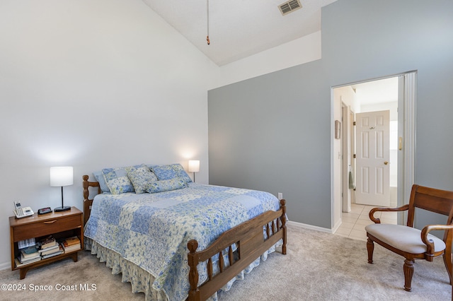 carpeted bedroom with high vaulted ceiling