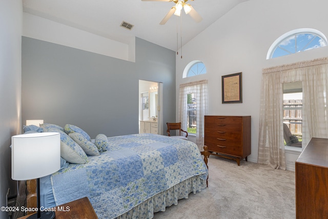 carpeted bedroom with ensuite bathroom, high vaulted ceiling, and ceiling fan