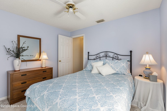 bedroom with carpet, a textured ceiling, and ceiling fan