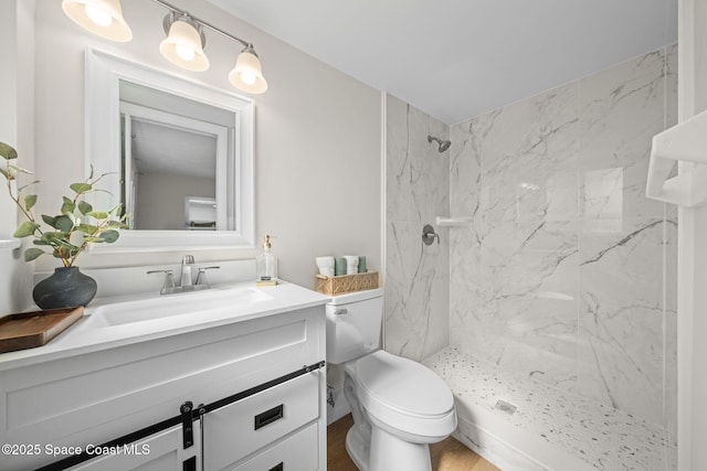 bathroom with vanity, toilet, and a tile shower