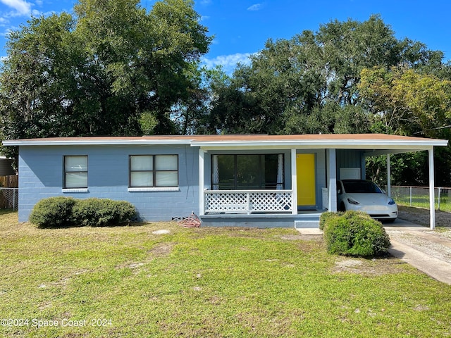 view of front of property with a front lawn, a carport, and covered porch