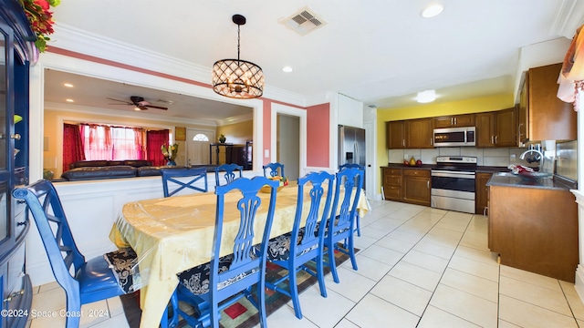 tiled dining area featuring ornamental molding and ceiling fan with notable chandelier