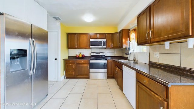 kitchen featuring light tile patterned floors, stainless steel appliances, sink, and tasteful backsplash