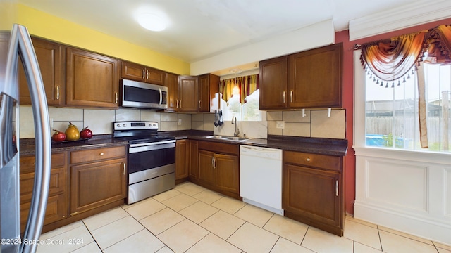 kitchen with tasteful backsplash, appliances with stainless steel finishes, and sink