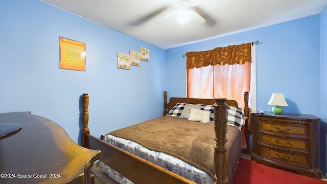 bedroom featuring ceiling fan, dark carpet, and a textured ceiling