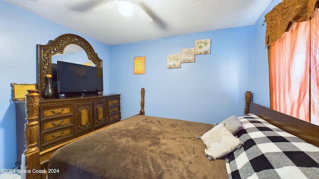 carpeted bedroom with ceiling fan and a textured ceiling