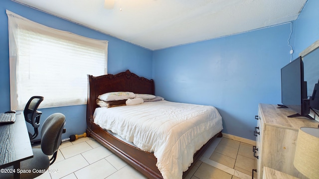 tiled bedroom featuring ceiling fan