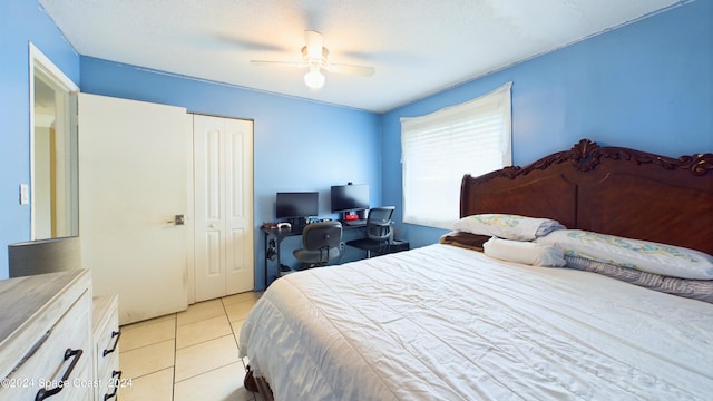 tiled bedroom featuring a closet, a textured ceiling, and ceiling fan