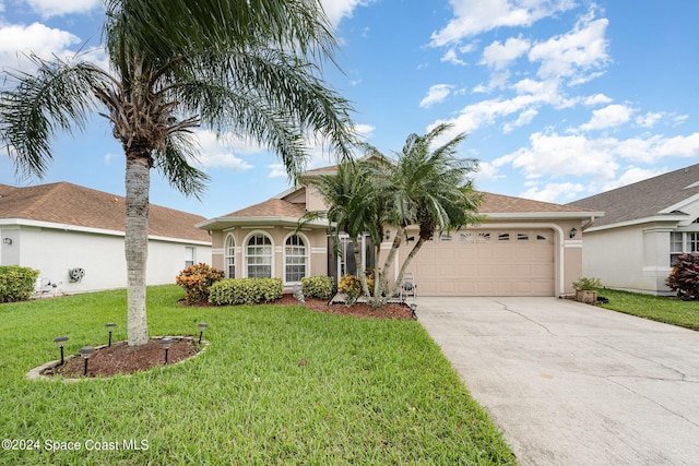 4889 Worthington Cir, Rockledge, FL 32955 - mediterranean / spanish-style home featuring a front yard, stucco siding, driveway, and a garage