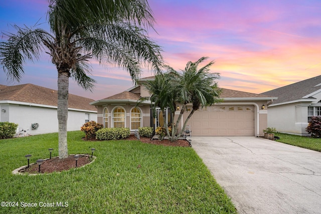 4889 Worthington Cir, Rockledge, FL 32955 - mediterranean / spanish-style house with an attached garage, concrete driveway, stucco siding, and a lawn