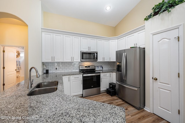 4889 Worthington Cir, Rockledge, FL 32955 - kitchen featuring a sink, white cabinets, light wood-type flooring, arched walkways, and appliances with stainless steel finishes