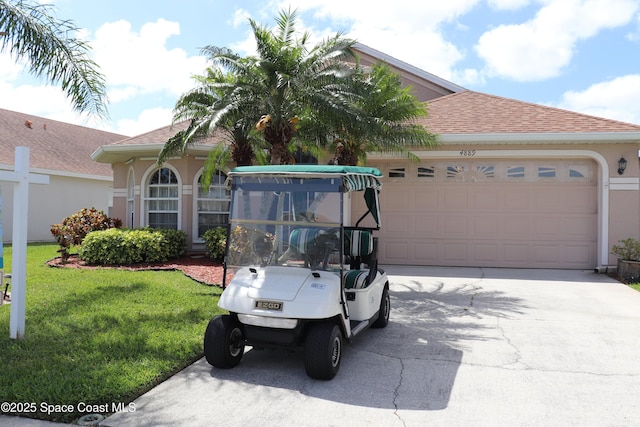 4889 Worthington Cir, Rockledge, FL 32955 - view of front of house featuring a garage, stucco siding, concrete driveway, a shingled roof, and a front lawn