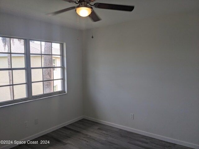 spare room with dark wood-type flooring and ceiling fan