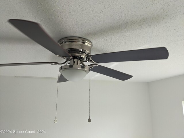 interior details featuring ceiling fan and a textured ceiling