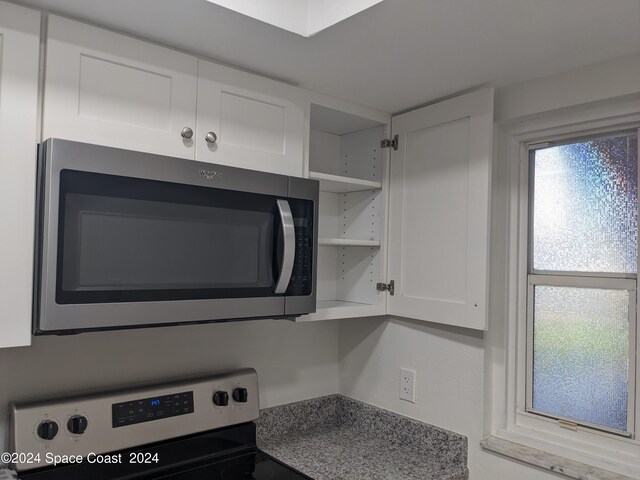 kitchen with range and white cabinets