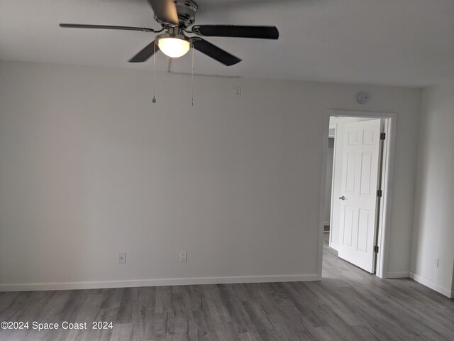 empty room featuring ceiling fan and dark hardwood / wood-style flooring