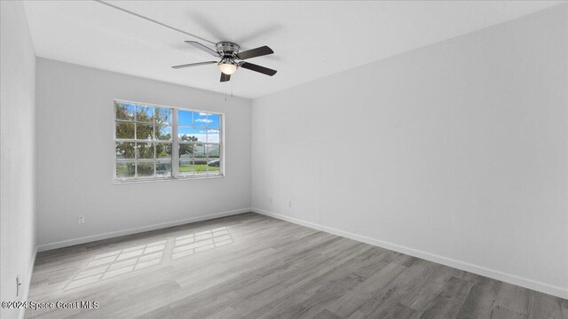 spare room with light wood-type flooring and ceiling fan