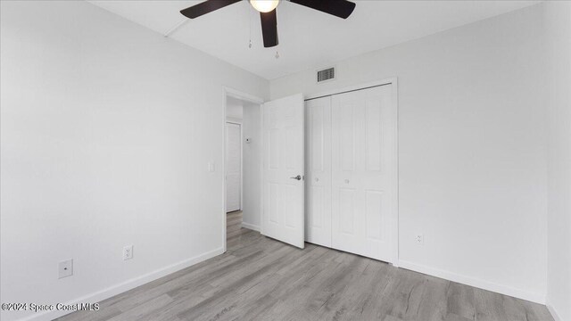 unfurnished bedroom with a closet, light hardwood / wood-style floors, and ceiling fan