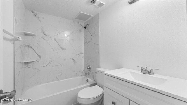 full bathroom featuring toilet, tiled shower / bath, a textured ceiling, and vanity