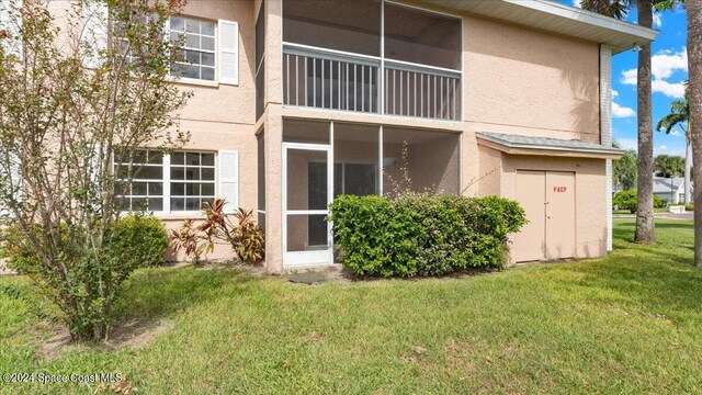 rear view of property with a yard and a sunroom