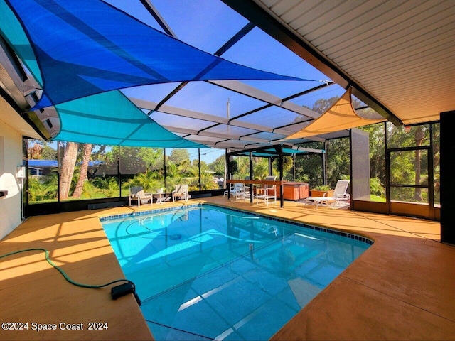 view of pool featuring glass enclosure and a patio area