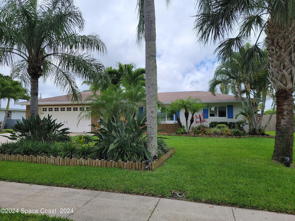 view of front facade with a front yard and a garage