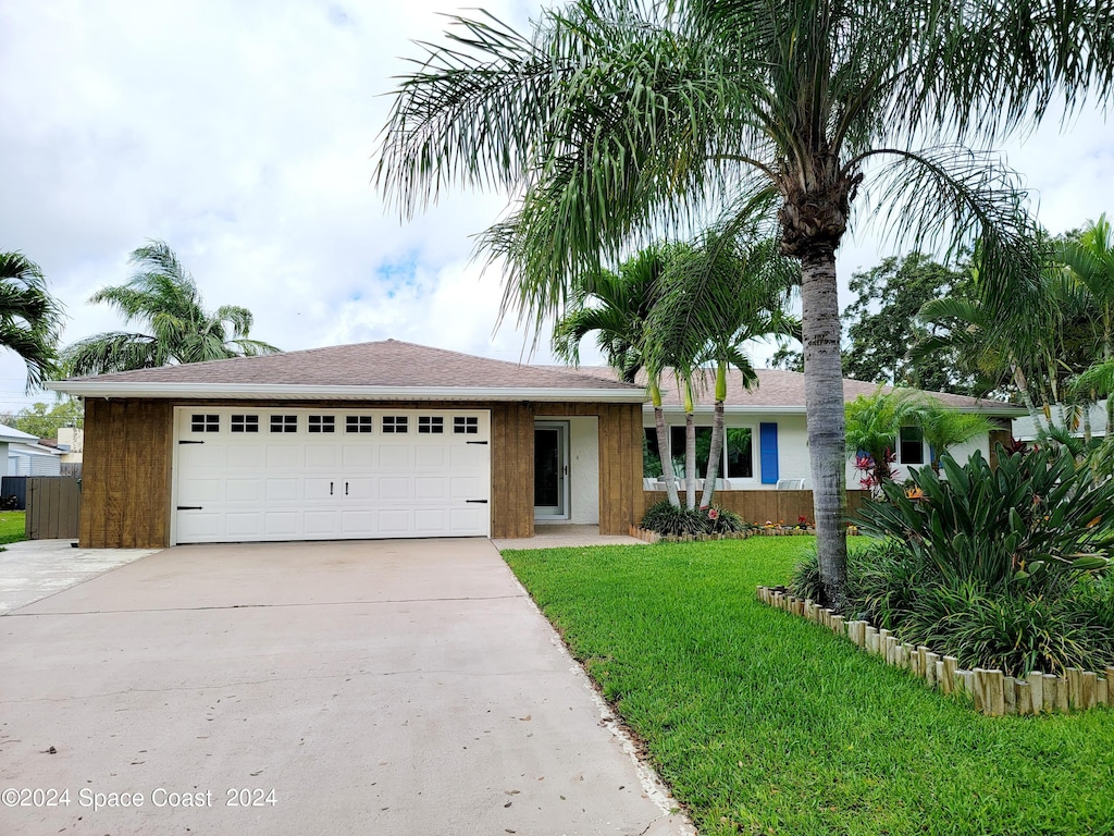 ranch-style home with a garage and a front lawn