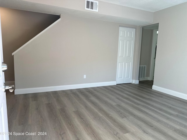 empty room featuring a textured ceiling and wood-type flooring