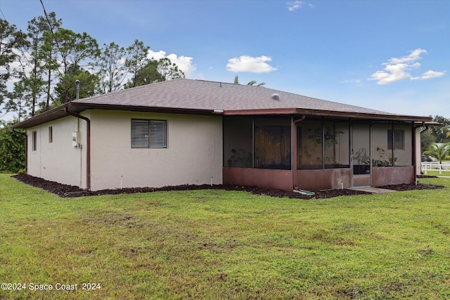 back of property featuring a yard and a sunroom