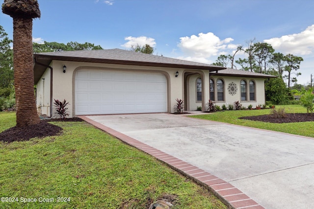 single story home with a garage and a front lawn