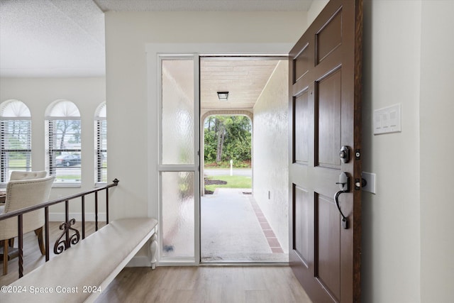 foyer entrance featuring light hardwood / wood-style floors and a textured ceiling