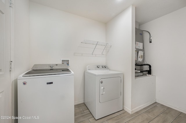 washroom with water heater and washer and clothes dryer