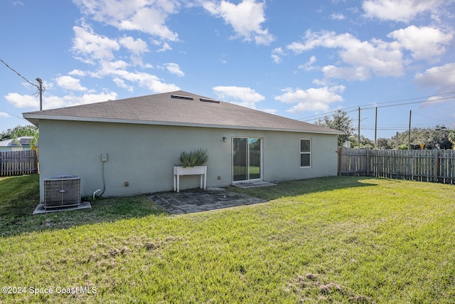 rear view of property featuring a yard, a patio, and central air condition unit