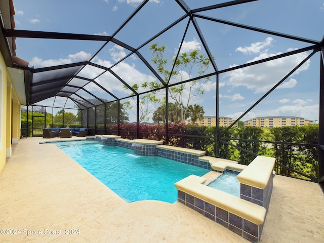 view of pool with an in ground hot tub, glass enclosure, a patio area, and pool water feature