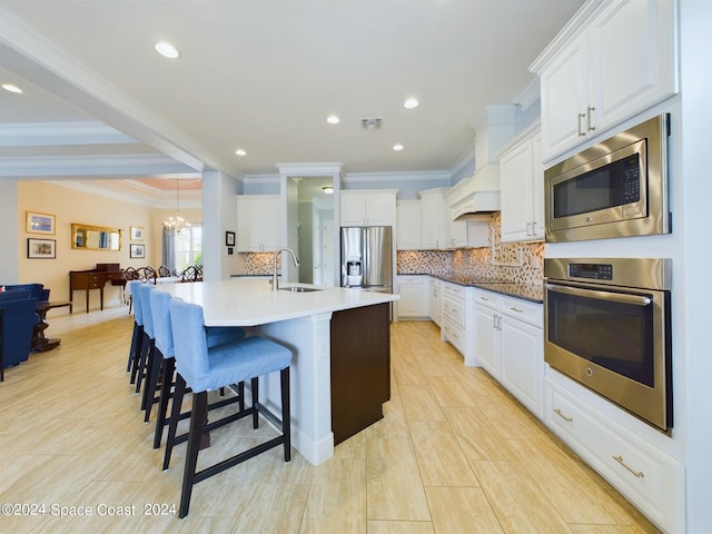 kitchen with white cabinets, appliances with stainless steel finishes, sink, and a large island