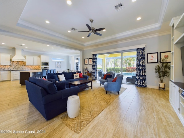 living room featuring a raised ceiling and crown molding