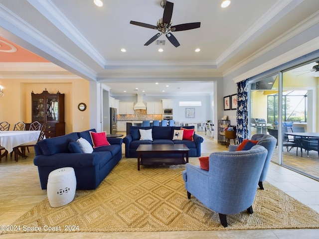 living room featuring ornamental molding, a tray ceiling, and light tile patterned floors