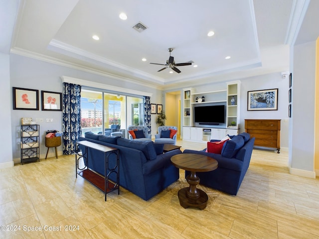 living room featuring built in features, crown molding, ceiling fan, and a raised ceiling