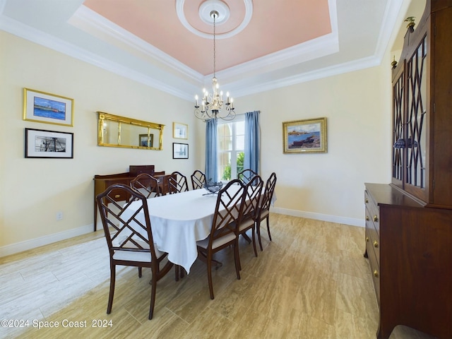 dining room featuring ornamental molding, a notable chandelier, and a raised ceiling