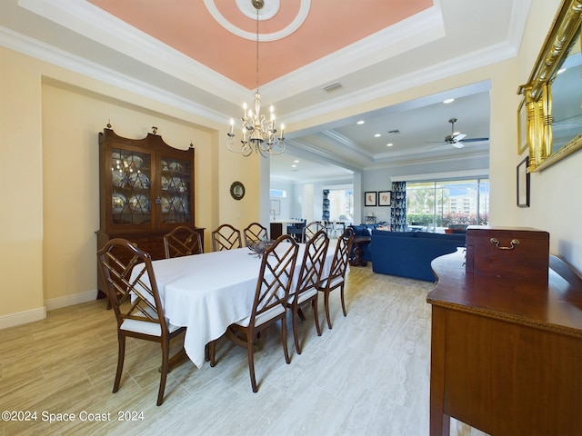 dining area featuring a raised ceiling, ceiling fan with notable chandelier, crown molding, and light hardwood / wood-style floors